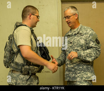 Col. Jaime Dailey, commander of 67th Troop Command, Iowa Army National Guard, presents a challenge coin to a Soldier of the 209th Area Support Medical Company for exemplary service during the unit's Joint Readiness Training Center (JRTC) rotation July 19, 2016, in Fort Polk, La.  The Iowa medical personnel joined more than 5,000 Soldiers from other state Army National Guard units, active Army and Army Reserve troops as part of the 27th Infantry Brigade Combat Team task force.  The Soldiers will hone their skills and practice integrating combat operations ranging from infantry troops engaging i Stock Photo