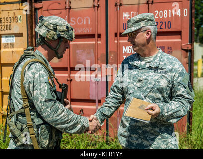 Col. Jaime Dailey, commander of 67th Troop Command, Iowa Army National Guard, presents a challenge coin to 1st Sgt. Peter Moeller, with the 209th Area Support Medical Company, for exemplary service during the unit's Joint Readiness Training Center (JRTC) rotation July 19, 2016, in Fort Polk, La.  The Iowa medical personnel joined more than 5,000 Soldiers from other state Army National Guard units, active Army and Army Reserve troops as part of the 27th Infantry Brigade Combat Team task force.  The Soldiers will hone their skills and practice integrating combat operations ranging from infantry  Stock Photo