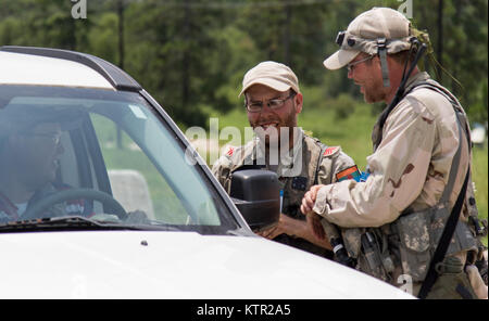 Two soldiers from Atropia, a fictitious country that has called upon the U.S. Military for aide, conduct an identification check at an entry control point in the Army’s Joint Readiness Training Center, Fort Polk, La., July 23, 2016. A role-playing opposing force of more than 500 people are outfitted with Multiple Integrated Laser Engagement Systems and assume a tactical combat role against more than 3,000 Army National Guard Soldiers from New York and 2,000 Soldiers from other state Army National Guard units, active Army and Army Reserve troops as part of a training event with the 27th Infantr Stock Photo