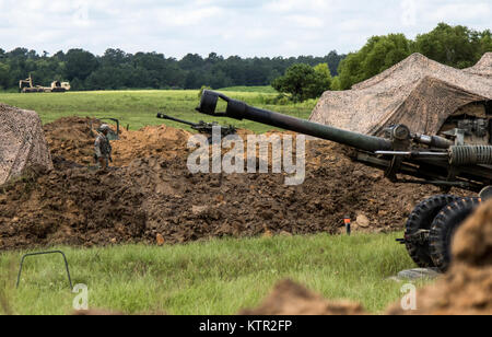 A Soldier with the New York Army National Guard's Bravo Battery, 1st Battalion, 258th Field Artillery Regiment, walks in between two 105mm howitzers at a temporary artillery position at the Army’s Joint Readiness Training Center, Fort Polk, La., July 26, 2016. The artillerymen joined more than 3,000 Soldiers from New York and 2,000 Soldiers from other state Army National Guard units, active Army and Army Reserve troops as part of the 27th Infantry Brigade Combat Team task force.  The Soldiers will hone their skills and practice integrating combat operations ranging from infantry troops engagin Stock Photo