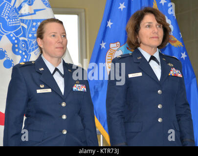 LATHAM, N.Y. --  Michelle Buonome (left) and Col. Maureen Murphy, director of staff - air, New York Air National Guard (right), stand at attention as the order promoting Buonome to the rank of lieutenant colonel is read during Buonome's promotion ceremony at New York National Guard Headquarters here on Nov. 22. Buonome, who enlisted in the New York Air National Guard in 1997, currently serves as Deputy Human Resources Officer for the 16,000-member New York National Guard, and as the commander of the 109th Force Support Squadron. (U.S. Army National Guard photo by Master Sgt. Raymond Drumsta/re Stock Photo