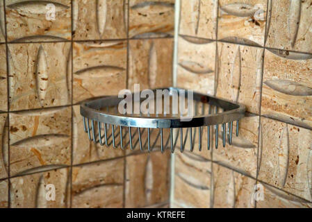 Wire soap holder on wall in bathroom Stock Photo