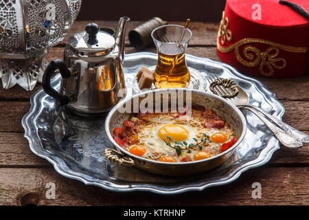 Fried egg with cured meat, traditional turkish breakfast, served in metal dishware, rustic Stock Photo