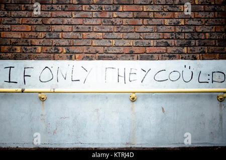 Graffiti on a wall above a yellow handrail Stock Photo