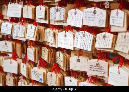 Ema, Japanese wooden wishing plaques with prayers and wishes written on them, hanging at a Shinto shrine in Kyoto, Japan. Stock Photo