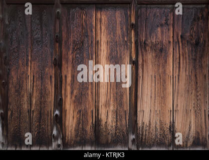 Japanese charred dark brown cedar wood of an exterior wall, Shou Sugi Ban or Yakisugi traditional charring technique, texture background. Architectura Stock Photo