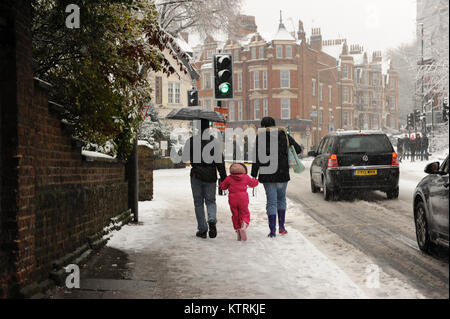 People walk through the snow during heavy snowfall on Muswell Hill Road in London, England on December 2017 Stock Photo