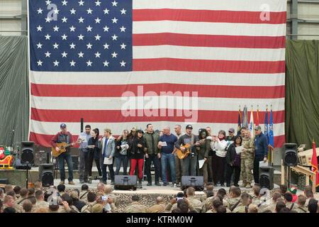 U.S. Army Medal of Honor Recipient Florent Groberg, actor Adam Devine, comedian Iliza Shlesinger, World Wrestling Entertainment (WWE) wrestlers Alicia Fox, Gail Kim and The Miz (Michael Mizanin), professional chef Robert Irvine, U.S. Joint Chiefs of Staff Chairman Joseph Dunford and country music singer Jerrod Niemann perform on stage for U.S. soldiers during the USO Holiday Tour at the Bagram Airfield December 24, 2017 in Bagram, Afghanistan. Stock Photo