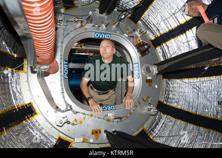 NASA astronaut Randy Bresnik looks through the hatch of the International Space Station's Bigelow Expandable Aerospace Module (BEAM) on July 31, 2017. The BEAM is an experimental expandable module just over halfway into its planned two-year demonstration on the space station. Stock Photo