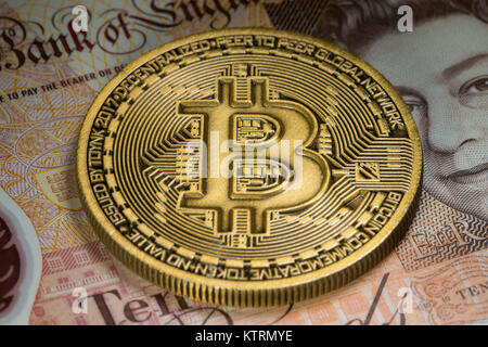 Gold Bitcoin coin on a tenner ten pound note Stock Photo