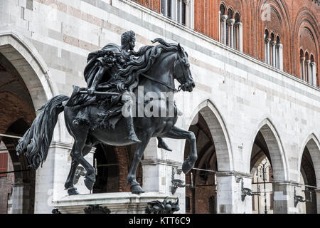 One of the Equestrian Statues of the Farnese Family in the Piazza Cavalli of Piacenza, Emilia-Romagna, Italy, with the Palazzo Comunale or Palazzo Got Stock Photo