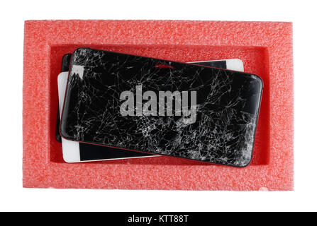 Broken defective smartphones are waiting for their repair in a plastic red industrial box. Isolated on white top view concept studio shot Stock Photo