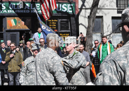 U.S. Army Captain Dennis Tierney, right, passes the colors of the New York Army National Guard's Company A, 1st Battalion, 69th Infantry to his first sergeant, Sgt. 1st Class Jairo Aquino, following his assumption of command ceremony in New York City March 17, 2017. Tierney and his Soldiers conducted the ceremony following the unit activities for the Army's famous &quot;Fighting 69th&quot; as they led the New York City St. Patrick's Day Parade up 5th Avenue. The unit ceremony was held on New York's lower east side, near the site of the unit's former armory. The battalion, with its unique Irish Stock Photo