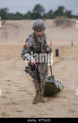 Vermont Army National Guard Specialist Avery Cunningham carries a rescue dummy on a litter from one end of the firing range to another during a training scenario at the Region One Best Warrior Competition at Joint Base McGuire-Dix-Lakenhurst on 26 April 2017.  Fourteen Soldiers are competing in the three-day event, April 25-27, 2017, which features timed events, including urban warfare simulations, a 12-mile ruck march, land navigation, and the Army Physical Fitness Test. The two winners will go on to compete in the 2017 Army National Guard Best Warrior Competition to be named the Army Guard's Stock Photo