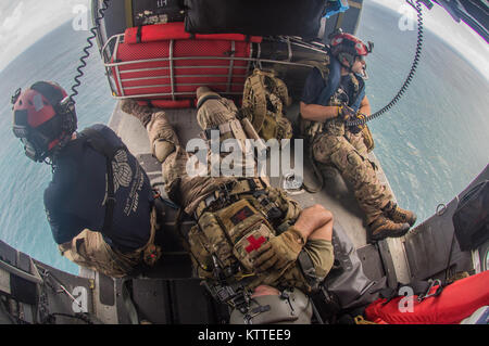 Flight crew and pararescuemen relax on the way home from their sortie.  Airmen from the New York Air National Guard's 106th Rescue Wing fly over St. Thomas and St. John in an HH-60 Pave Hawk helicopter on 10 September, 2017.  They're searching for people in need of critical assistance in the wake of Hurricane Irma. Stock Photo