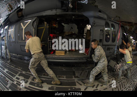 Airmen unload an HH-60 Pave Hawk helicopter from the back of a C-17 Globemaster III.   The New York Air National Guard's 106th Rescue Wing returns home from a deployment to San Juan, Puerto Rico on 12 September, 2017.  They were performing airlift and rescue missions in the Caribbean in response to the devastation caused by Hurricane Irma. Stock Photo