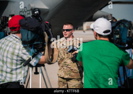 Staff Sgt. Eric Scheffer, a squad leader assigned to the 105th Military Police Company, Buffalo, New York Army National Guard, talks to local news about what their mission will be when the 105th MP Co. arrive in the U.S. Virgin Islands to provide hurricane relief, Niagara Falls, N.Y., Sept. 25, 2017. More than 20 members of the 105th MP Co. loaded equipment and personnel and began their deployment to the U.S. Virgin Islands ahead of more Soldiers flying later in the week. (Air National Guard photo by Staff Sgt. Ryan Campbell) Stock Photo