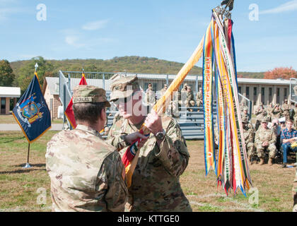 Lt. Col. Seth L. Morgulas, outgoing commander of the 369th Special Troops Battalion (STB), hands the battalion colors to Col. Stephen M. Bousquet, commander of the 369th Sustainment Brigade, during a change of command ceremony at Camp Smith, NY, October 22, 2017. The passing of the colors symbolizes Lt. Col. Morgulas’ relinquishing command of the unit. The 369th STB returned this summer from a successful 9 month deployment to the Middle East. (US Army photo by Sgt. Jeremy Bratt) Stock Photo