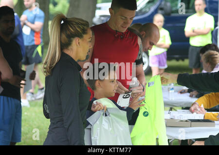 Registrants receive their runner's t-shirts at the New York Family Readiness Council fundraising 5k run. Dozens of National Guard and community runners will participate in the 4th 'Hometown Heroes Run', a fundraiser sponsored by the New York National Guard Family Readiness Council on Sunday, June 12th at Colonie Crossings Park Stock Photo