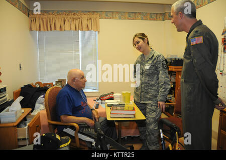 Master Sgt. Carrie Gillen and Lt. Col. Russell Strasburger visits Anthony Russo, United States Army Veteran, during an annual holiday party supported by Stewart Air National Guard Base at the Veteran’s Home in Montrose, New York. (Air National Guard Photo by Airman 1st Class Deanna De Laura) 111203-Z-GJ424-016 Stock Photo