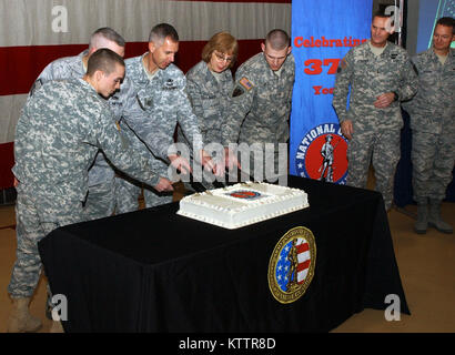 Five Soldiers and Airmen from the New York National Guard whose birthdays fell on Dec. 13, the same day as the National Guards 375th Birthday cut the birthday cake simultaneously as Maj. Gen. Patrick Murphy, the state adjutant general and Brig. Gen Anthony German, the deputy adjutant general look on. The Soldiers and Airmen are, from left: Spec. Justin Phillips, 1427th Transportation Company; Master Sgt. Ian Tucker, 174th Fighter Wing; Sgt. Major David Smith, Headquarters 42nd Infantry Division; Master Sgt. Brenda Baxter, 152nd Air Operations Group; and Sgt. Joseph Dumas, 827th Engineer Compan Stock Photo