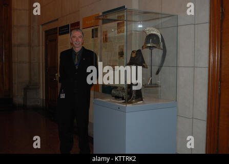 ALBANY-- New York State Military Museum employee Wayne Clark stands beside a display of 19th Century military headgear worn by members of the New York Militia. The display, on the history of the New York Militia and National Guard, was unveiled as part of Gov. Andrew M. Cuomo's opening new historic exhibits at the State Capitol to on Jan. 4, 2012 as part of the events surrounding his State-of-The-State message. The display was prepared by the New York State Military Museum.The For more information go to this website: hallofgovernors.ny.gov. Stock Photo