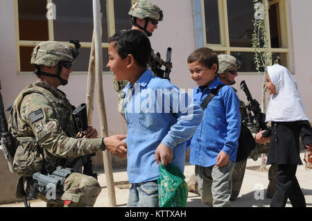 Sgt. 1st Class Grant Burtch, platoon sergeant for the personal security detail, Lt. Col. Joseph Gabriel, operations officer, and Sgt. John Dewey, team leader for the PSD, all assigned to Headquarters Company, 37th Infantry Brigade Combat Team shake hands with students as they leave the Aliabad School near Mazar-e-Sharif, Balkh Province, Afghanistan, April 3, 2012. A new school is being built for the students as one of the 37th's commander's emergency relief program projects. The 37th IBCT is deployed to Afghanistan in support of Operation Enduring Freedom. (37th IBCT photo by Sgt. Kimberly Lam Stock Photo