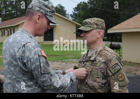Maj. Gen. Patrick Murphy “pins” rank insignia on newly-promoted Maj. Richard Redmond, of the 2-108th Infantry battalion, during a promotion ceremony held at Camp Shelby Joint Forces Training Center. Murphy visited with several units of the 27th IBCT as they prepare to deploy in support of overseas contingency operations. (U.S. Army photo by Staff Sgt. Kenny Hatten, CSJFTC Public Affairs-released.) Stock Photo