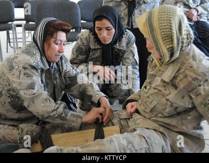 Sgt. N. Kahle Wright of Columbus, Ohio, combat medic assigned to Charlie Company, 237th Brigade Support Battalion, 37th Infantry Brigade Combat Team, looks on as two female Afghan Batrol Police soldiers practice splint techniques during training at the ABP 5th Zone near Mazar-e-Sharif, Balkh Province, Afghanistan, April 24, 2012. The 37th IBCT is deployed to Afghanistan in support of the International Security Assistance Force in order to build Afghan National Police capacity. (37th IBCT photo by Sgt. Kimberly Lamb) (Released) Stock Photo
