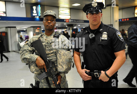 New York Army National Guard Sgt. Leopoldo DeSilva (left) pulls security duty in Pennsylvania Station on Wednesday, May 2 with an Amtrack Police Officer. The Soldiers are members of the New York National Guard’s Joint Task Force Empire Shield which provides security augmentation to law enforcement agencies at transportation hubs in the New York metro area. The team was part of a Multi-Agency Super Surge (MASS) in which police saturate key transportation nodes to deter attacks. The May 2 MASS was the 100th time the New York National Guard supported that kind of security operation. Stock Photo