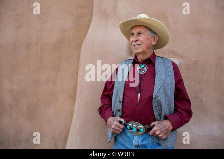 Old cowboy posing in front of adobe on San Fransicso Street, Santa Fe, New Mexico Stock Photo