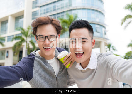Two Vietnamese men traveler taking selfie in foreign city Stock Photo