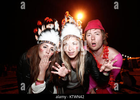 At Roskilde Festival it's tradition that people dress up and disguise in many ways. Here a group of girls is having a good time as dressed up like native American indians. Denmark 2010. Stock Photo