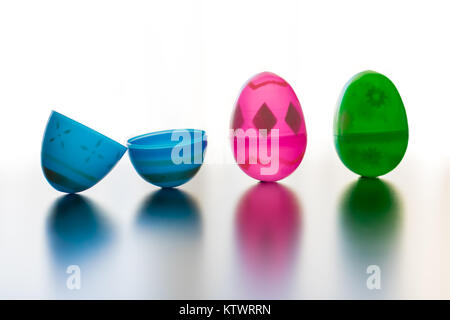 Blue, pink and green designed easter eggs are photographed stand up. The blue egg is opened symbalizing Jesus' openned tomb. The eggs cast colored sha Stock Photo