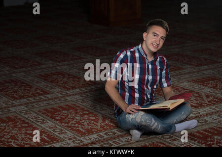 Young Muslim Man Is Reading The Koran In The Mosque Stock Photo