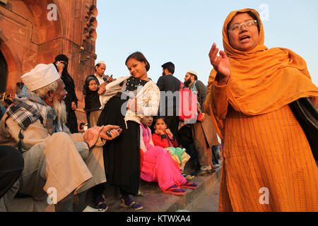 Muslim men and women on the steps outside the entrance to the Jama Masjid in New Delhi, India Stock Photo