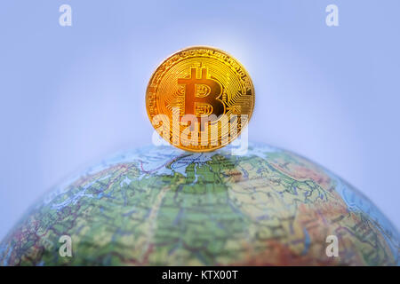 gold bitcoin with gold bitcoin symbol and Earth. Bitcoin as a symbol world currency. The cryptocurrency bitcoin on the globe. Stock Photo