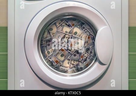 money in washing machine close up. concept of laundering illegal money. washing dirty American banknotes nominal value one hundred dollars Stock Photo