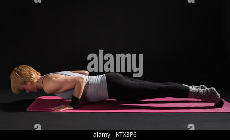 Woman yoga trainer doing a variation of Chaturanga Dandasana (four-limbed  staff) pose Stock Photo - Alamy
