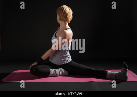 Young woman practicing yoga, Matsyendrasana / Spine-Twisting Pose Stock Photo