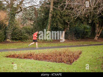 A man in a red top jogs through Ropner Park, Richmond Road, Stockton-on-Tees, United Kingdom Stock Photo