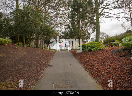 A man and woman cycle through Ropner Park, Richmond Road, Stockton-on-Tees, United Kingdom Stock Photo