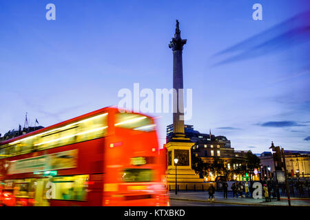 Red bus passing Nelson's Column in Trafalgar Square, London, England, United Kingdom, Europe Stock Photo