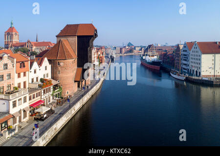 Gdansk old city in Poland with the oldest medieval port crane (Zuraw) in Europe,  St John church, Motlawa River, old  granaries, ship and yacht. Stock Photo