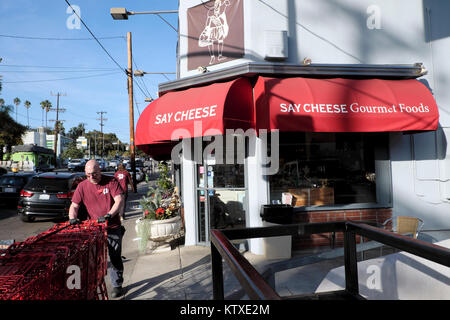 Trader Joes supermarket workers collecting carts outside Say Cheese gourmet food store in Silver Lake  Los Angeles, California USA    KATHY DEWITT Stock Photo