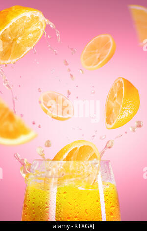 Fresh lemons falling in juice with lot of huge splashes on pink Stock Photo