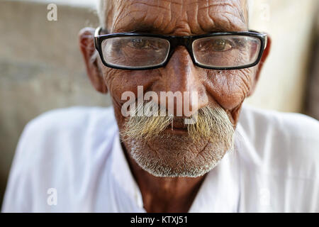 Portrait of senior indian man wearing turban and glassess in the village near Pushkar, Rajasthan, India. Stock Photo