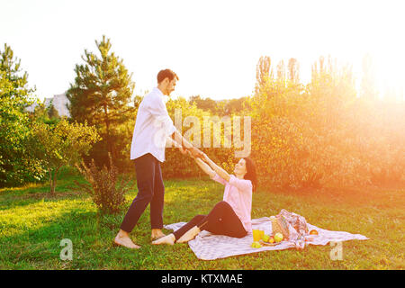 Happy pregnant couple in park on picnik Stock Photo