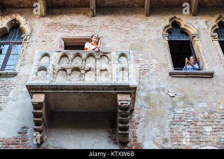 Two tourist girls making pictures in the balcony that inspired the tragedy Romeo and Juliet written by William Shakespeare. Casa di Giulietta, Verona, Stock Photo
