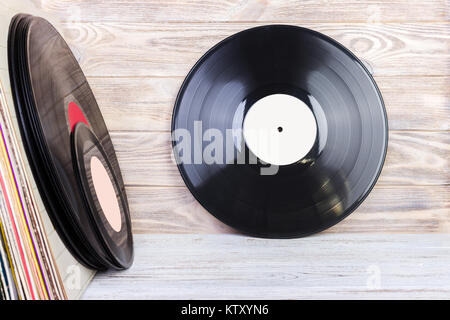 Retro styled image of a collection of old vinyl record lp's with sleeves on a wooden background. Copy space. Stock Photo